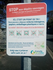 Panneau "stop aux dépôts sauvages" près des containers de recyclage
